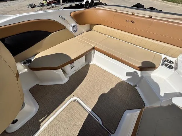 Slide: The Image of 2018 Sea Ray SPX 210 boat interior with tan seating and carpeted floor. - 7