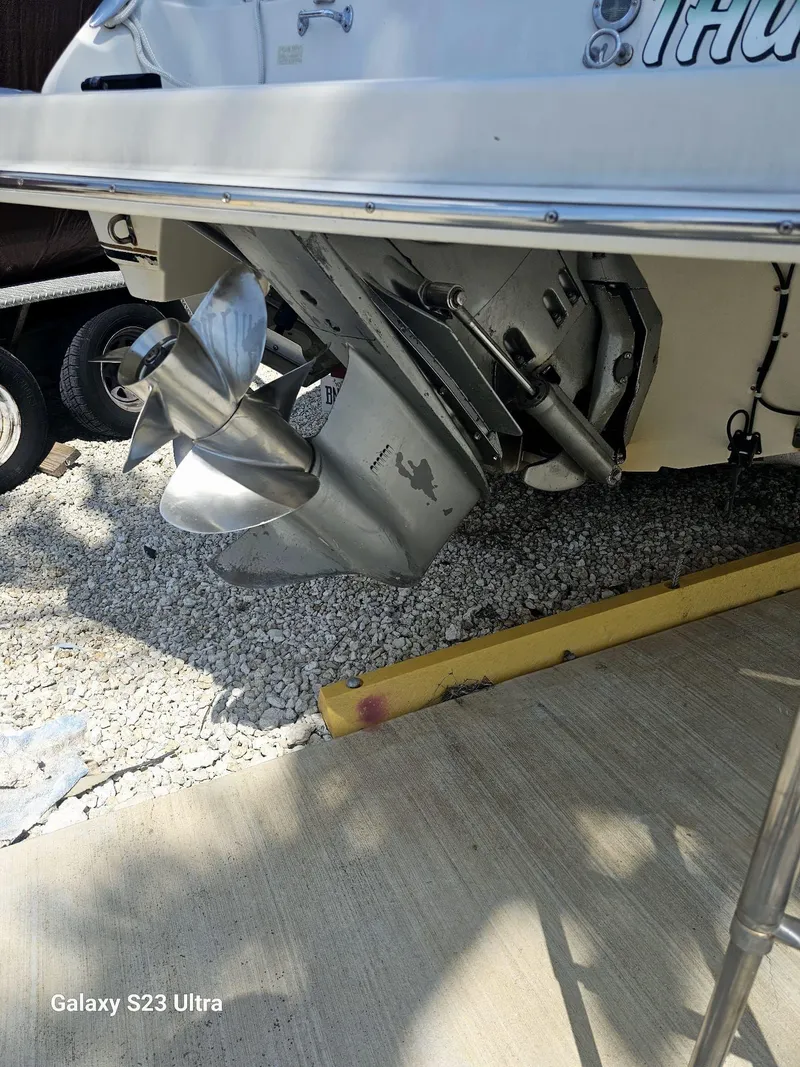 Slide: The Image of 2000 Regal 2800 LSR boat propeller and stern, parked on gravel. - 19