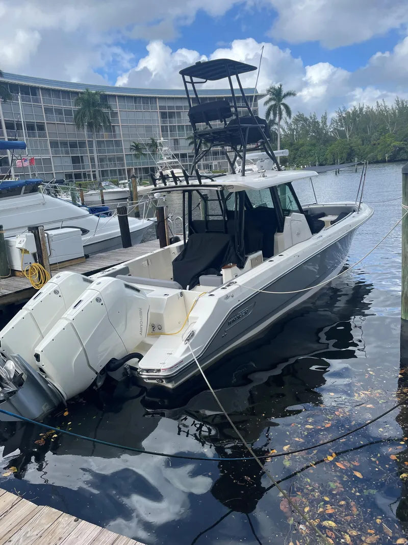 Slide: The Image of 2000 Regal 2800 LSR boat docked at marina, surrounded by water and palm trees. - 21