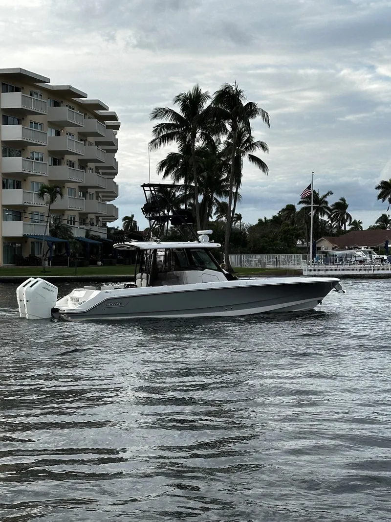 Slide: The Image of Regal 2800 LSR boat cruising near waterfront buildings and palm trees, 2000 model. - 22