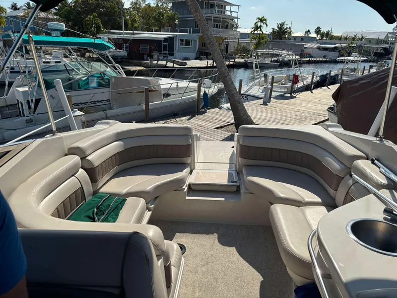 Slide: The Image of 2000 Regal 2800 LSR boat interior with spacious seating at a marina. - 9