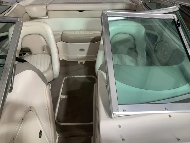 Slide: The Image of Interior of a 2006 Bryant 206 BR boat with white seating and glass windshield. - 16