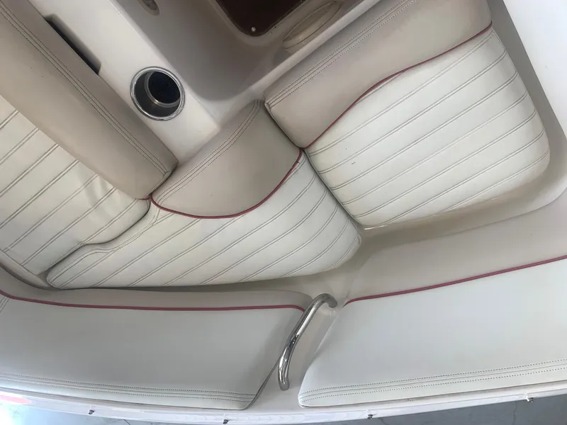 Slide: The Image of 2006 Bryant 206 BR boat interior with white and beige seating, red accents, and cup holder. - 36