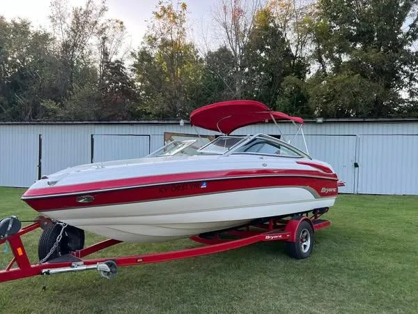 Slide: The Image of 2006 Bryant 206 BR boat on trailer, red and white, parked on grass. - 6