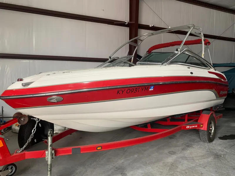 Slide: The Image of 2006 Bryant 206 BR boat with red accents on a trailer in a storage facility. - 8