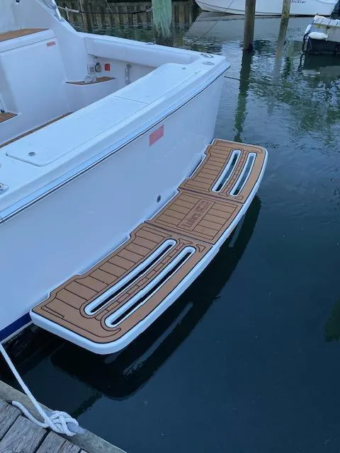 Slide: The Image of 2006 Luhrs 28 Open boat with teak swim platform docked in calm water. - 11