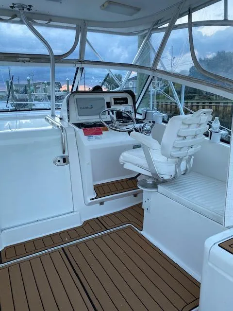 Slide: The Image of 2006 Luhrs 28 Open boat cockpit with steering wheel and seating, featuring wood accents. - 13