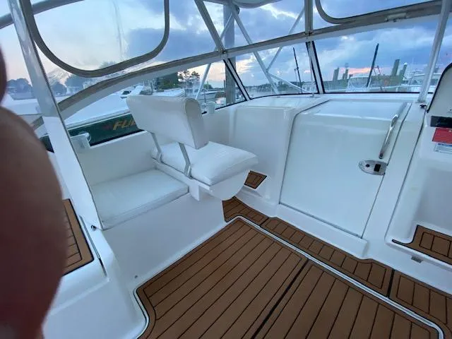 Slide: The Image of 2006 Luhrs 28 Open boat interior with white seating and wood flooring. - 15