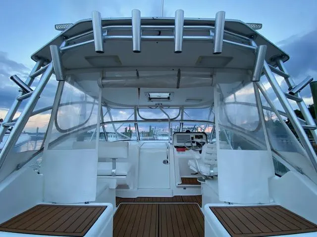 Slide: The Image of 2006 Luhrs 28 Open boat interior with seating and helm, featuring clear enclosures. - 4