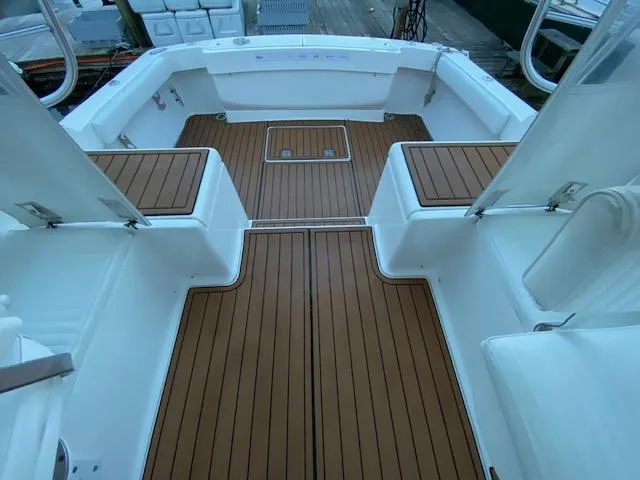 Slide: The Image of 2006 Luhrs 28 Open boat deck with teak flooring and white seating. - 6
