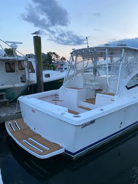 Slide: The Image of 2006 Luhrs 28 Open boat docked at sunset, featuring a spacious deck and sleek design. - 7