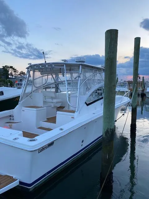 Slide: The Image of 2006 Luhrs 28 Open boat docked at sunset, showcasing sleek design and spacious deck. - 8