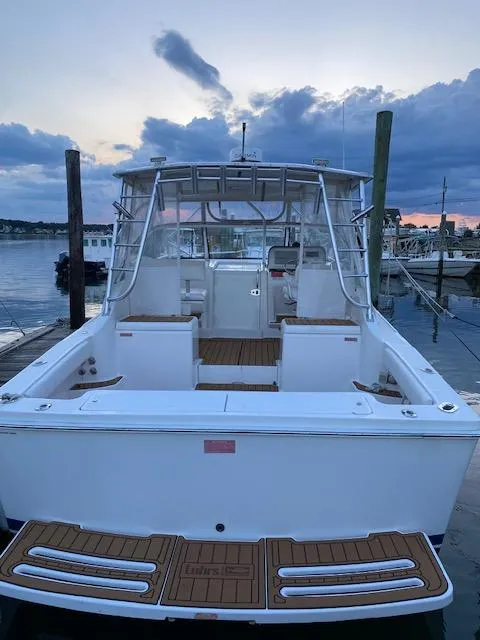 Slide: The Image of 2006 Luhrs 28 Open boat docked at sunset, featuring spacious deck and sleek design. - 9