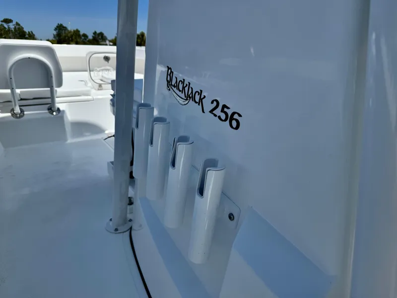 Slide: The Image of 2025 BlackJack 256 Coastal boat interior with rod holders and seating. - 12