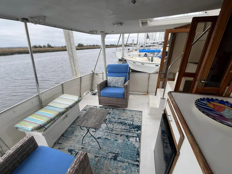 Slide: The Image of 1987 Jefferson 42 SE Sundeck Motor Yacht interior with seating, table, and river view. - 10