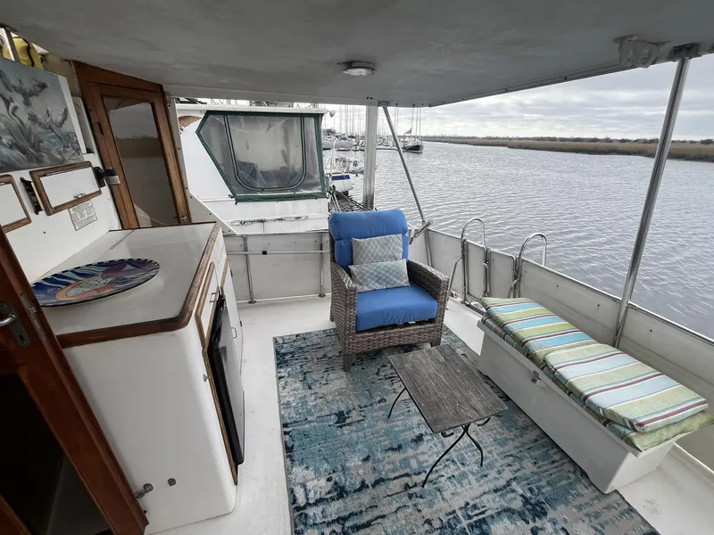 Slide: The Image of 1987 Jefferson 42 SE Sundeck Motor Yacht interior with seating, table, and river view. - 11