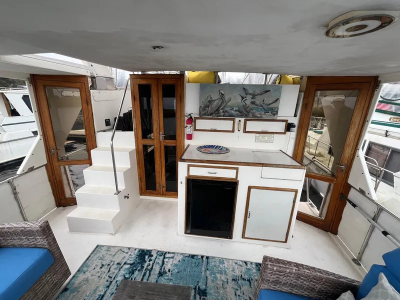 Slide: The Image of 1987 Jefferson 42 SE Sundeck Motor Yacht interior with kitchenette, seating, and wooden accents. - 12