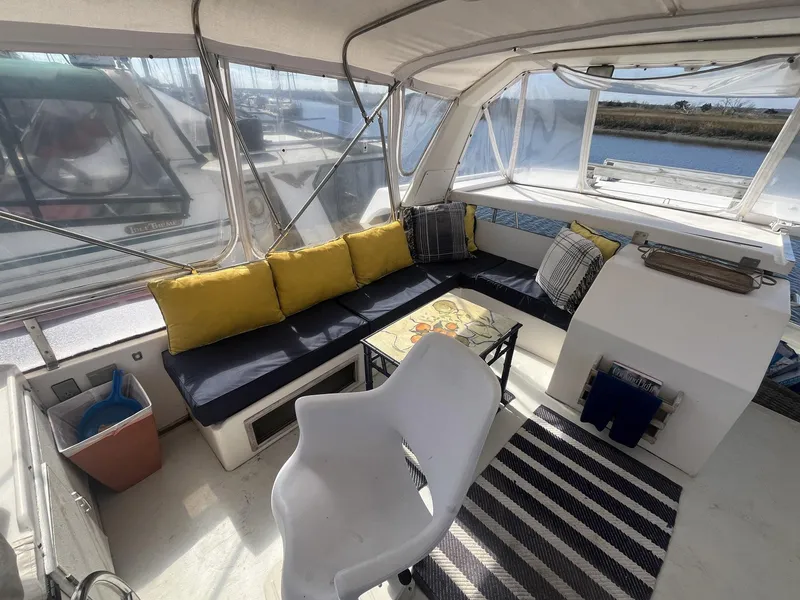 Slide: The Image of 1987 Jefferson 42 SE Sundeck Motor Yacht interior with seating, table, and striped rug. - 14