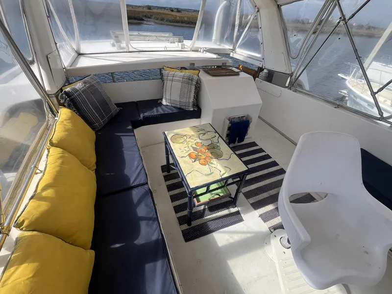Slide: The Image of 1987 Jefferson 42 SE Sundeck Motor Yacht interior with seating, table, and cushions. - 15