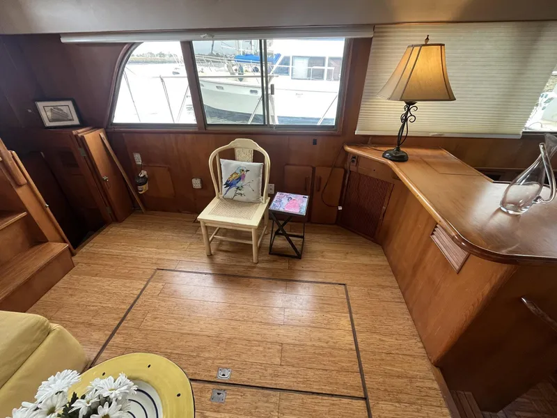 Slide: The Image of Interior of 1987 Jefferson 42 SE Sundeck Motor Yacht with wooden flooring and cozy seating area. - 19