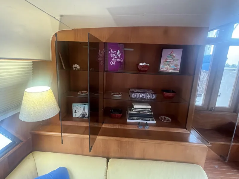 Slide: The Image of 1987 Jefferson 42 SE Sundeck Motor Yacht interior with wooden shelves and decorative items. - 21