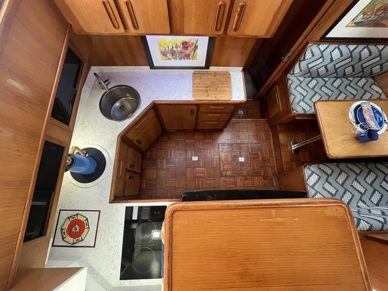 Slide: The Image of Interior of 1987 Jefferson 42 SE Sundeck Motor Yacht with wood cabinetry and dining area. - 25