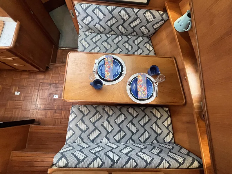 Slide: The Image of 1987 Jefferson 42 SE Sundeck Motor Yacht interior with patterned seating and set dining table. - 28