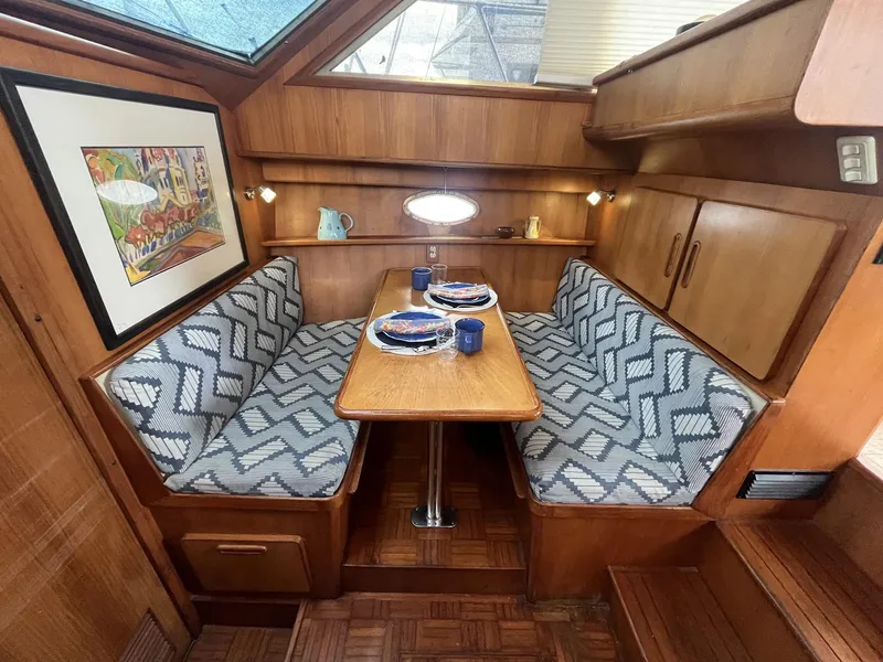Slide: The Image of 1987 Jefferson 42 SE Sundeck Motor Yacht interior with cozy dining area and patterned seating. - 29