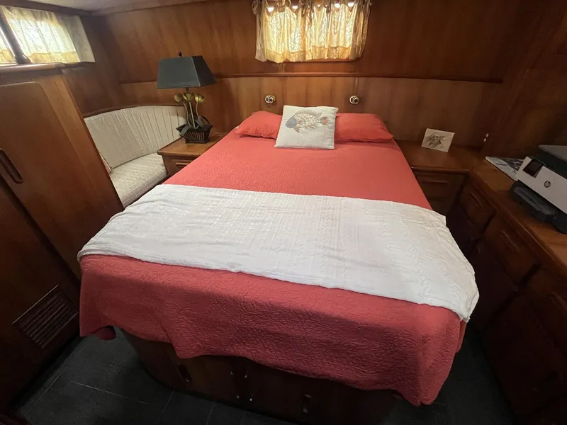 Slide: The Image of Cozy bedroom in 1987 Jefferson 42 SE Sundeck Motor Yacht with red bedding and wood paneling. - 31
