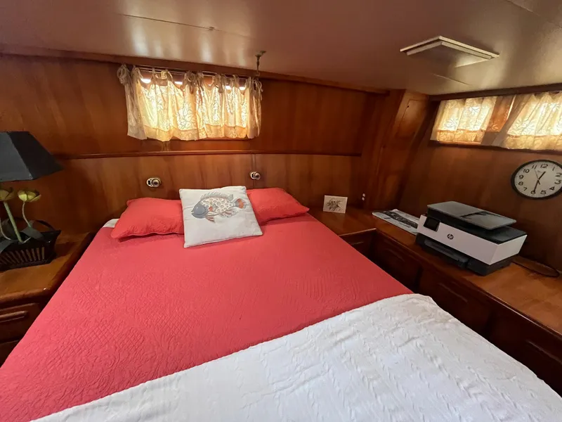 Slide: The Image of Cozy bedroom in 1987 Jefferson 42 SE Sundeck Motor Yacht with red bedding and wood paneling. - 32