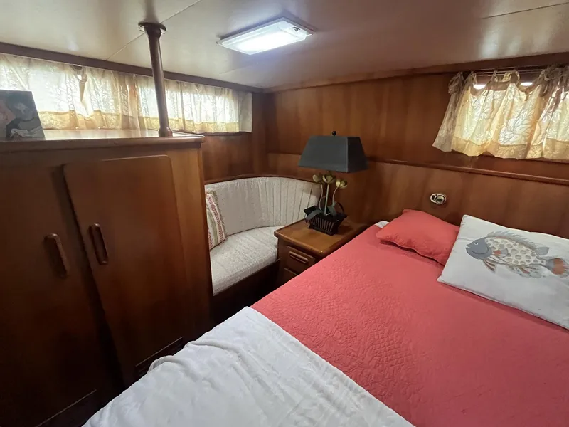 Slide: The Image of Cozy cabin interior of 1987 Jefferson 42 SE Sundeck Motor Yacht with bed and seating area. - 34