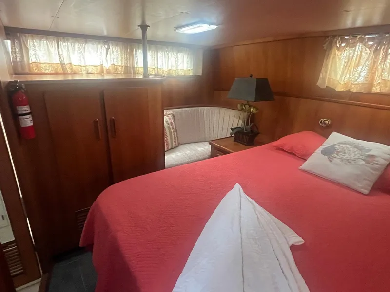 Slide: The Image of Cozy bedroom in 1987 Jefferson 42 SE Sundeck Motor Yacht with red bedding and wood paneling. - 36