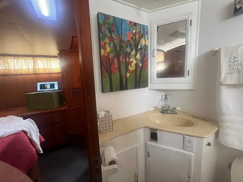 Slide: The Image of 1987 Jefferson 42 SE Sundeck Motor Yacht bathroom with sink, mirror, and colorful wall art. - 40