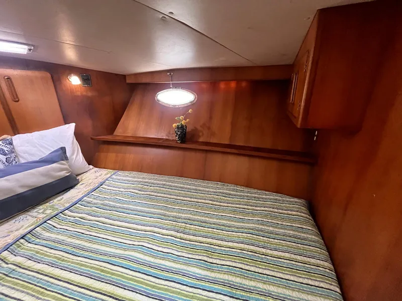 Slide: The Image of Cozy cabin interior of 1987 Jefferson 42 SE Sundeck Motor Yacht with striped bedding. - 44