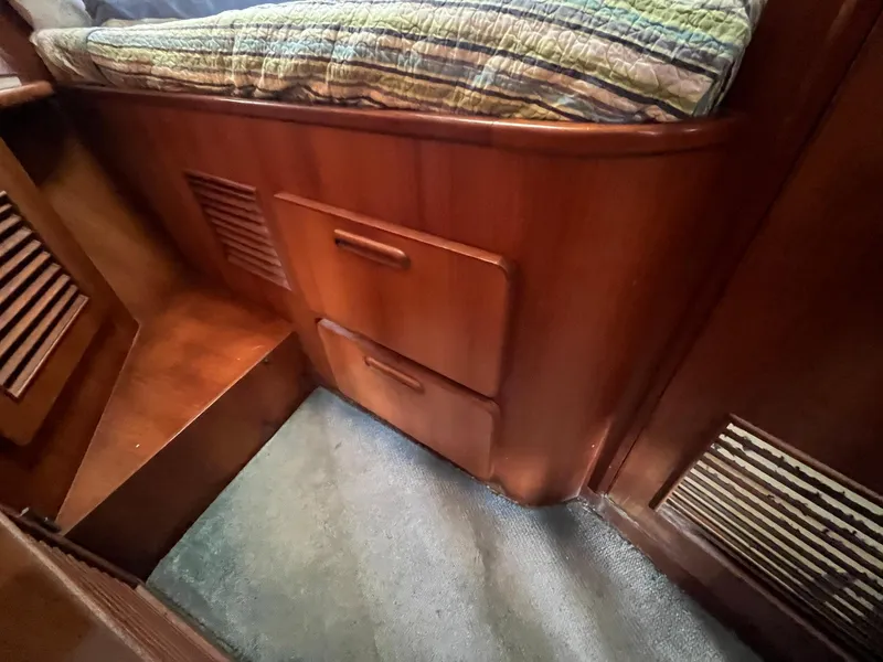 Slide: The Image of 1987 Jefferson 42 SE Sundeck Motor Yacht interior with wooden drawers and carpeted floor. - 46