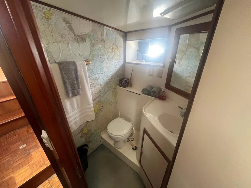 Slide: The Image of 1987 Jefferson 42 SE Sundeck Motor Yacht bathroom with map wallpaper and compact amenities. - 47