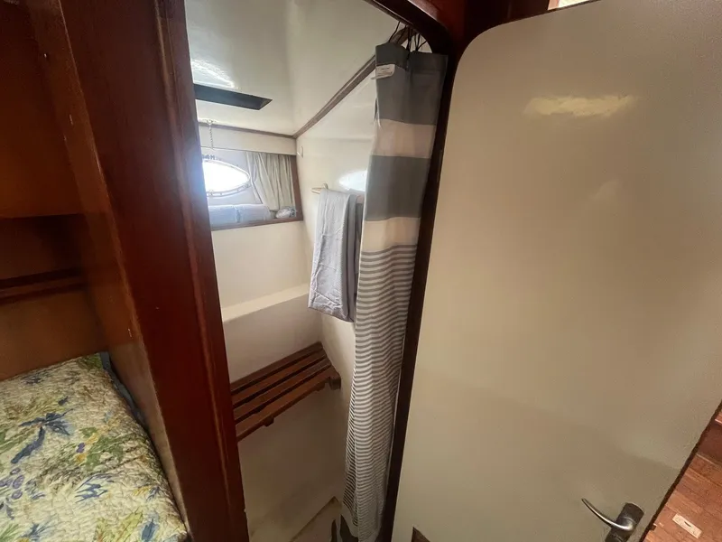 Slide: The Image of 1987 Jefferson 42 SE Sundeck Motor Yacht interior with cozy cabin and shower area. - 48
