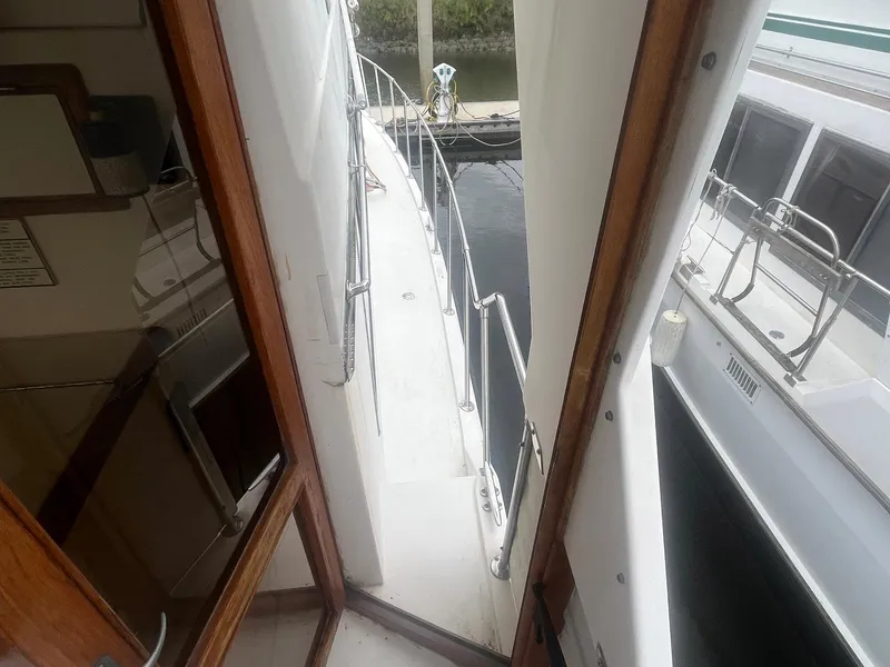 Slide: The Image of 1987 Jefferson 42 SE Sundeck Motor Yacht side deck view with railing and cabin entrance. - 7