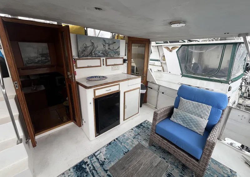 Slide: The Image of 1987 Jefferson 42 SE Sundeck Motor Yacht interior with seating, kitchenette, and nautical decor. - 9