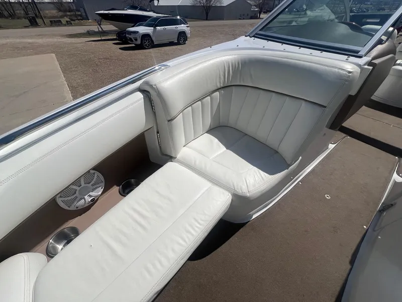 Slide: The Image of 2007 Cobalt 232 boat interior with white leather seating and cup holders. - 11