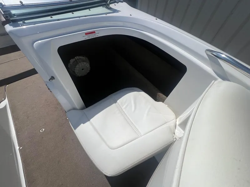 Slide: The Image of 2007 Cobalt 232 boat interior with white seating and storage compartment. - 14