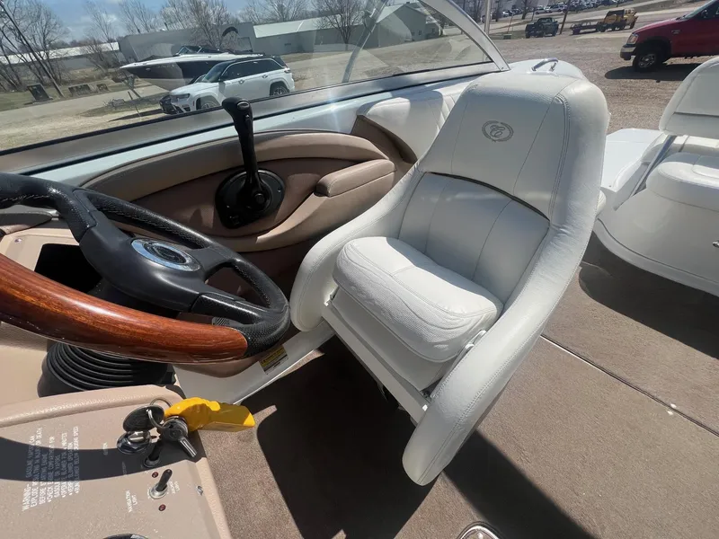 Slide: The Image of Interior of a 2007 Cobalt 232 boat with white seating and wooden steering wheel. - 18
