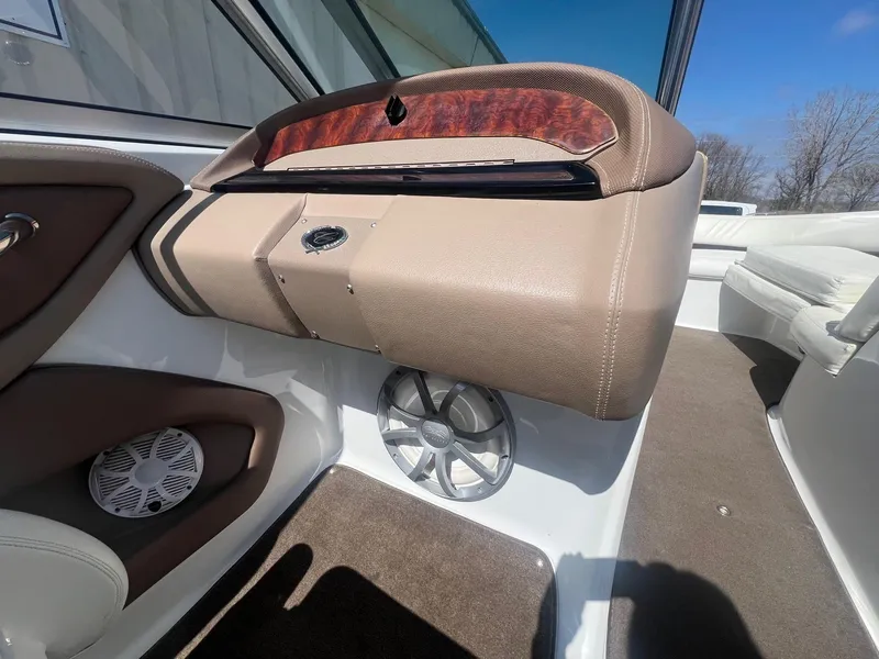 Slide: The Image of Interior of a 2007 Cobalt 232 boat, featuring beige upholstery and speaker system. - 20