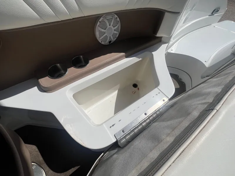 Slide: The Image of Interior of a 2007 Cobalt 232 boat featuring cup holders and a storage compartment. - 25
