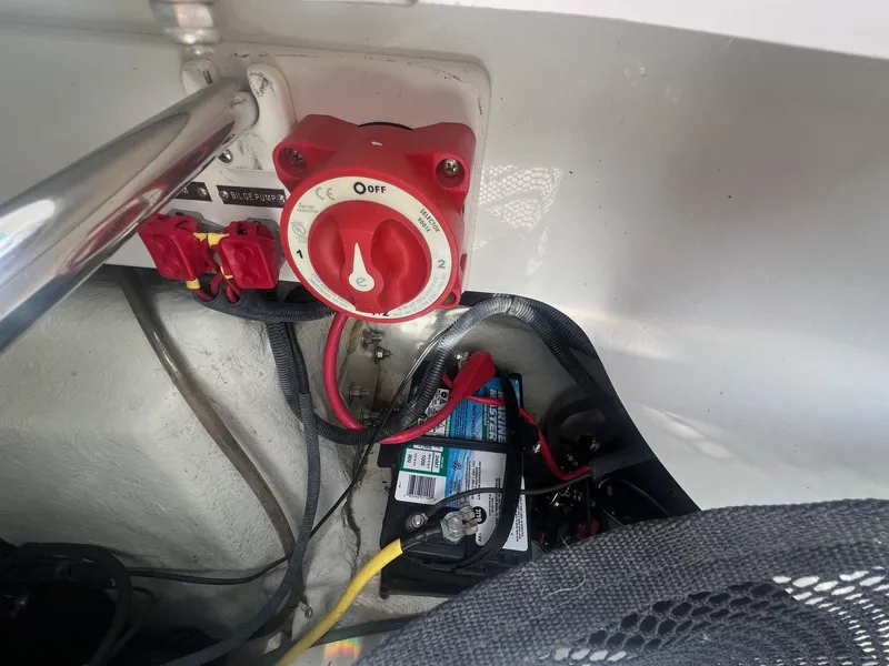 Slide: The Image of Battery compartment of a 2007 Cobalt 232 boat with red switch and wiring. - 28