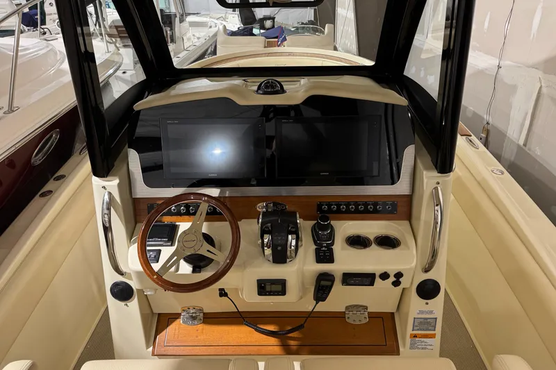 Slide: The Image of 2018 Chris-Craft Catalina 30 CL helm with dual screens and wooden steering wheel. - 28
