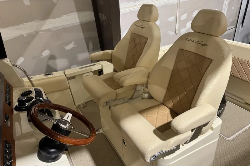 Slide: The Image of 2018 Chris-Craft Catalina 30 CL interior with luxurious beige seating and wooden steering wheel. - 30