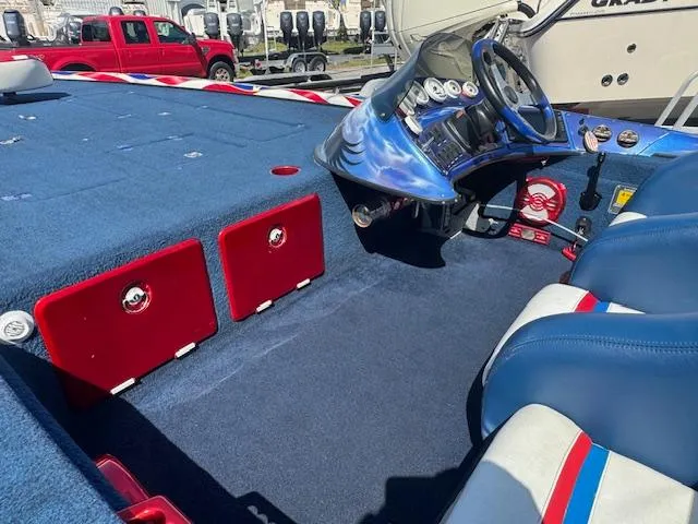 Slide: The Image of 2006 Storm Boats 22 interior with blue and red seating, dashboard, and steering wheel. - 8