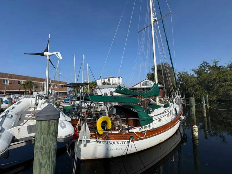 The Image of Sailboat "Tranquility" docked, Hans Christian 43T, 1989 model, with green covers and wind turbine. - 1