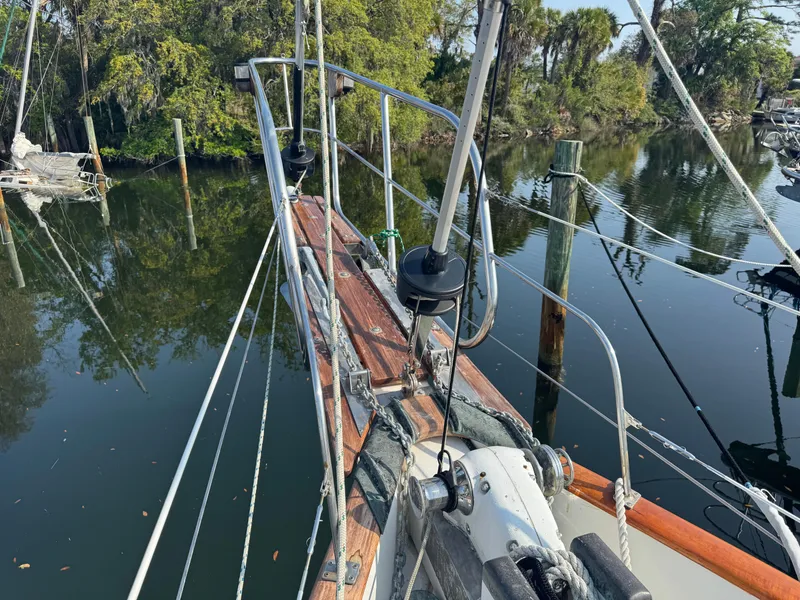 Slide: The Image of Sailboat deck view of 1989 Hans Christian 43T, docked near lush greenery. - 17